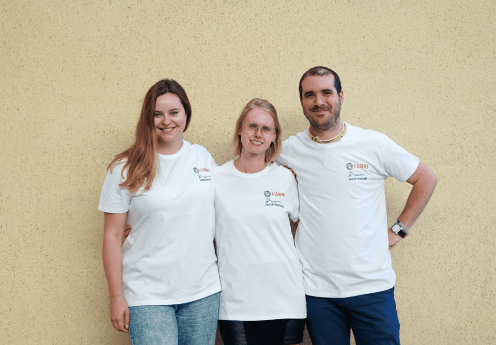 Deux femmes de l'équipe participante, accompagnées d'un autre collègue, portant fièrement tous les trois leur t-shirt avec la mention suivante : "Courir pour la santé mentale" avec le logo de l'Abri.
