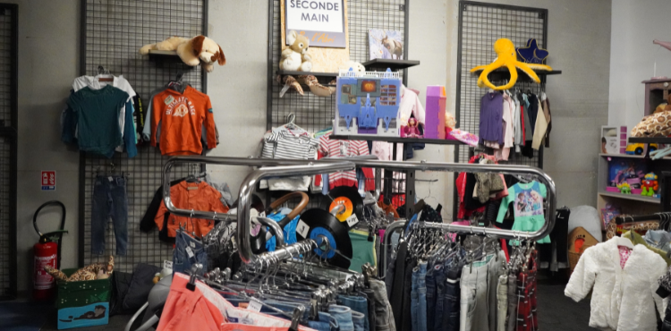 L'espace enfant du magasin, avec vêtements et jouets, toujours de seconde main. Les vêtements sont triés par taille sur des portants , comme dans un magasin classique.